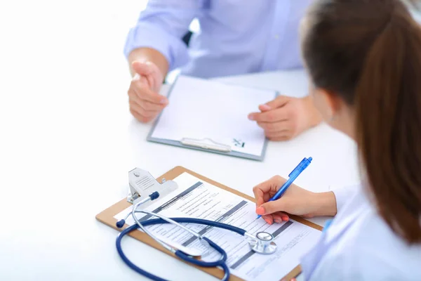 Doctor vrouw zitten met mannelijke patiënt aan de balie — Stockfoto