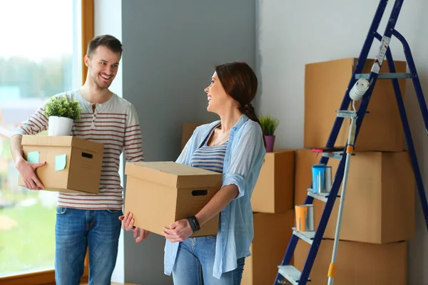 Glada unga par uppackning eller packa lådor och flyttar till ett nytt hem — Stockfoto