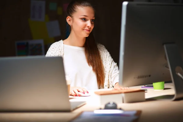 Jonge vrouw werkt in het kantoor, zit aan het bureau — Stockfoto