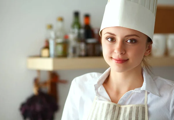 Junge Frau steht in ihrer Küche neben Schreibtisch — Stockfoto