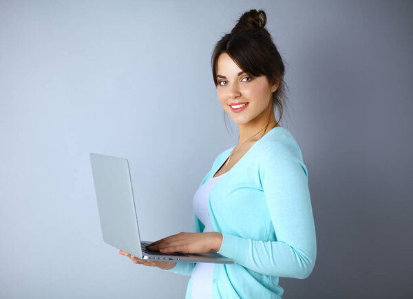 Happy young woman using her laptop