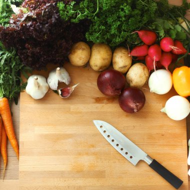 Mutfaktaki masanın üstünde sebzeler var.