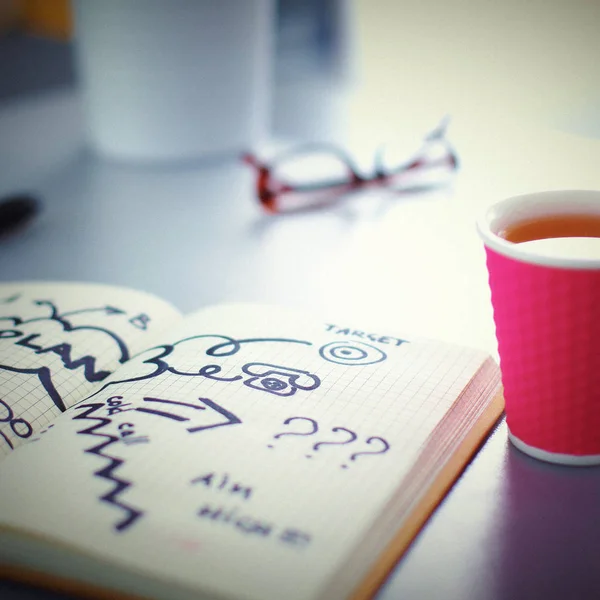 Note book with cup lying on the desk — Stock Photo, Image