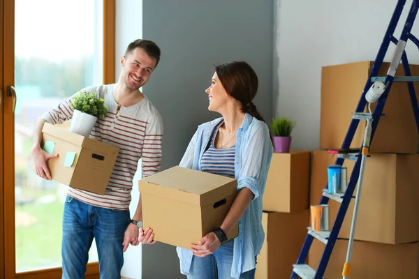 Gelukkige jonge paar uitpakken of dozen inpakken en verhuizen naar een nieuw huis — Stockfoto