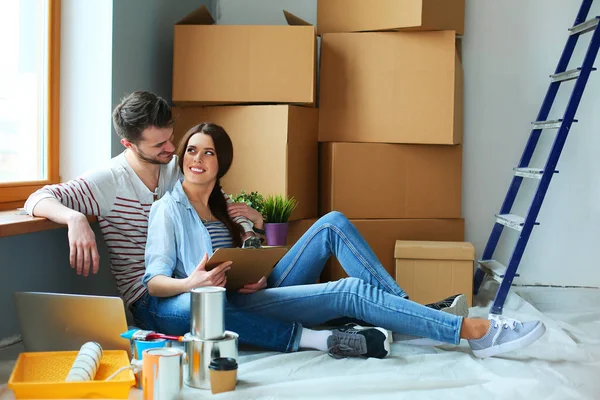 Jovem casal sentado no chão de seu novo apartamento — Fotografia de Stock