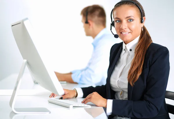 Glückliche Frau trägt Headset und sitzt auf dem Schreibtisch — Stockfoto