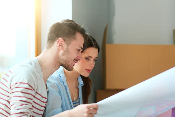 Feliz pareja joven desempacar o empacar cajas y mudarse a un nuevo hogar —  Fotos de Stock