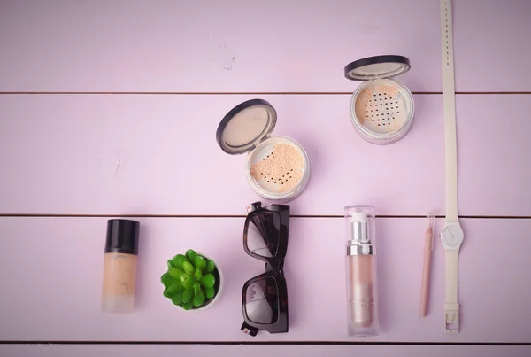 Okulary przeciwsłoneczne, kosmetyki makijaż i essentials na podłoże drewniane — Zdjęcie stockowe