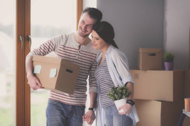 Mutlu genç çift açma veya kutu ambalaj ve yeni evine taşıdıktan