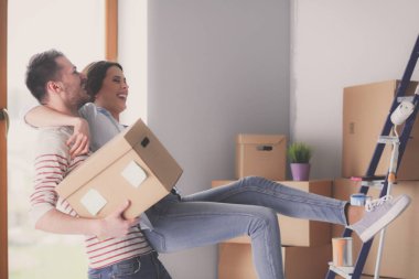 Mutlu genç çift açma veya kutu ambalaj ve yeni evine taşıdıktan