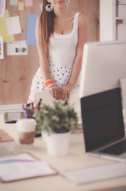 Ofiste çalışan genç bir kadın, masada oturuyor.