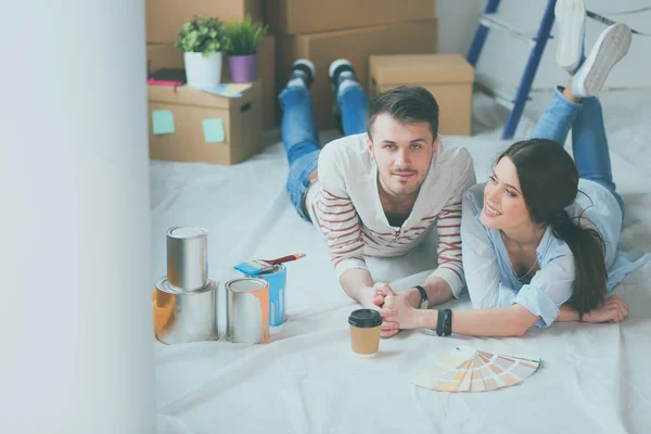 Paar verf kleur kiezen uit staal voor nieuw huis liggend op houten vloer — Stockfoto