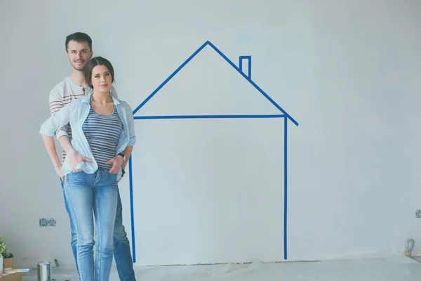 Par stående framför målade hem på vägg — Stockfoto
