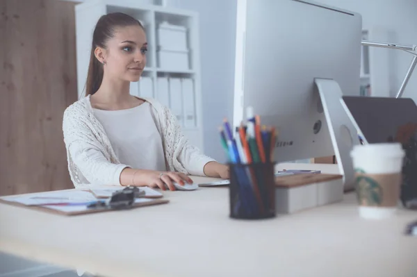 Mujer joven trabajando en la oficina, sentada en el escritorio — Foto de Stock