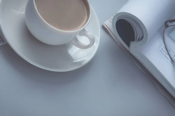 Una taza de café, papel y un bolígrafo en un portátil — Foto de Stock