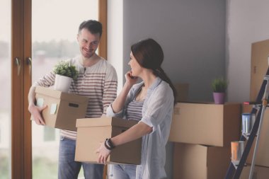 Mutlu genç çift açma veya kutu ambalaj ve yeni evine taşıdıktan