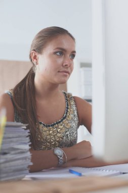 Moda tasarımcıları stüdyoda çalışıyor. Masanın üzerinde oturuyorlar.