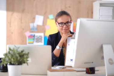 Moda tasarımcıları stüdyoda çalışıyor. Masanın üzerinde oturuyorlar.