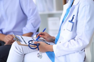 Hastanede masasında oturan genç bir kadın doktorun portresi.