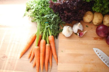 Mutfaktaki masanın üstünde sebzeler var.