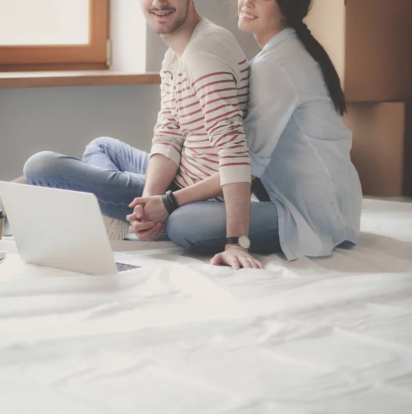 Молодая пара, сидящая на полу своей новой квартиры — стоковое фото