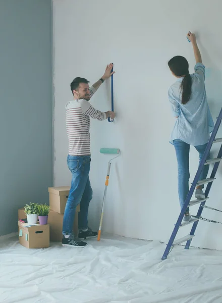 Portret van gelukkig lachend jong koppel schilderij interieur wand nieuw huis — Stockfoto