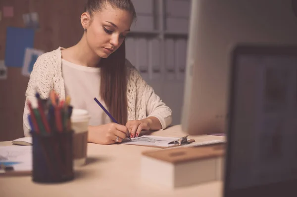 Mujer joven trabajando en la oficina, sentada en el escritorio — Foto de Stock