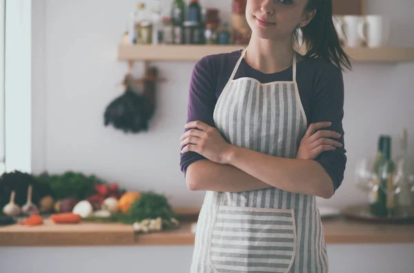 Jonge vrouw staan in haar keuken in de buurt van bureau — Stockfoto