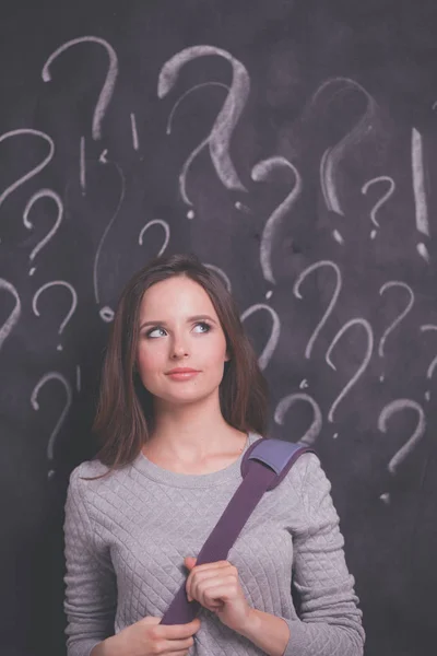 stock image Young girl with question mark on a gray background