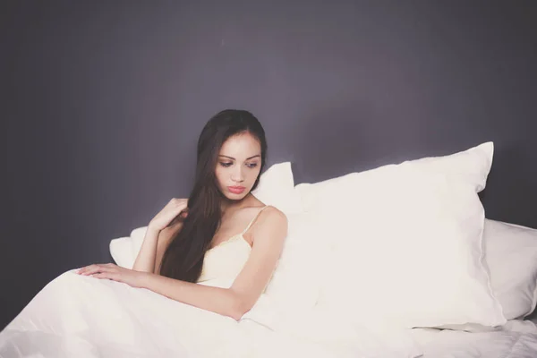 Bella donna seduta a letto — Foto Stock