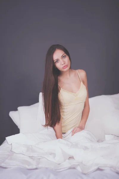 Bella donna seduta a letto — Foto Stock