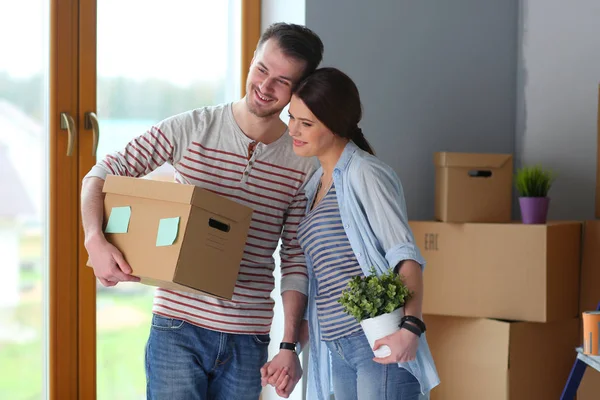 Gelukkige jonge paar uitpakken of dozen inpakken en verhuizen naar een nieuw huis — Stockfoto