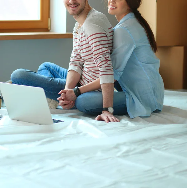 Giovane coppia seduta sul pavimento del loro nuovo appartamento — Foto Stock