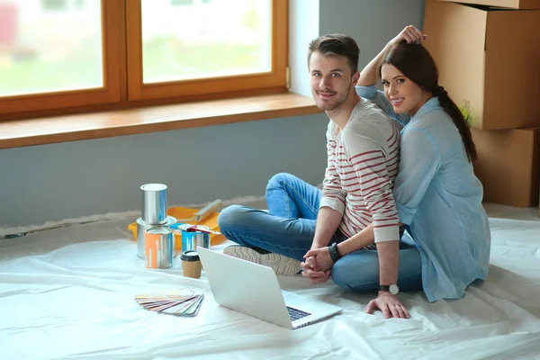 Giovane coppia seduta sul pavimento del loro nuovo appartamento — Foto Stock