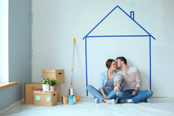 Par sitta framför målade hem på väggen — Stockfoto