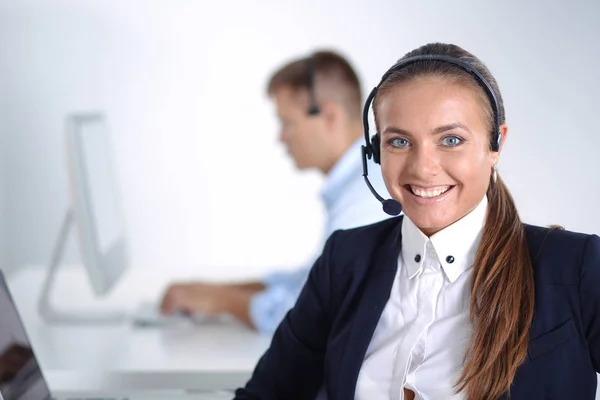 Gelukkig vrouwtje draagt een headset en zit op het bureau — Stockfoto