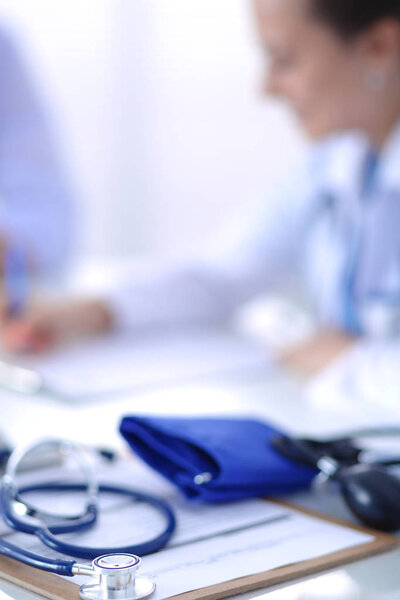 Portrait of young female doctor sitting at desk in hospital