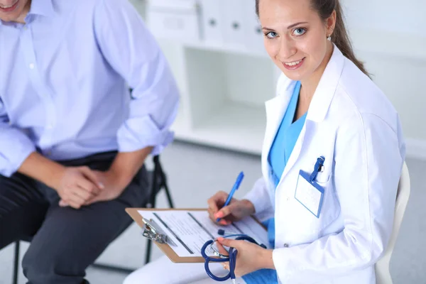 Portrait of young female doctor sitting at desk in hospital — Stock Photo, Image