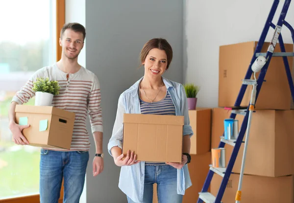 Gelukkige jonge paar uitpakken of dozen inpakken en verhuizen naar een nieuw huis — Stockfoto