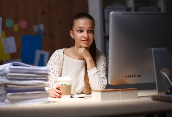 Jonge vrouw werkt in het kantoor, zit aan het bureau — Stockfoto