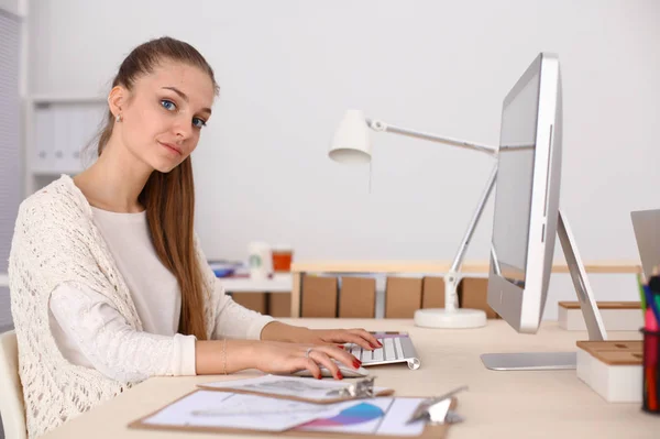 Jonge vrouw werkt in het kantoor, zit aan het bureau — Stockfoto