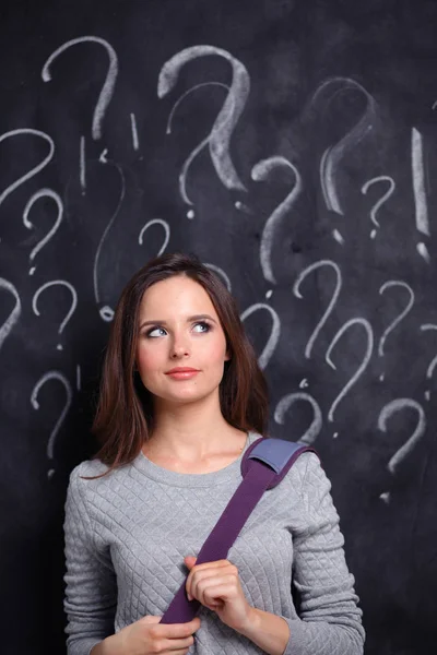 Jeune fille avec point d'interrogation sur un fond gris — Photo