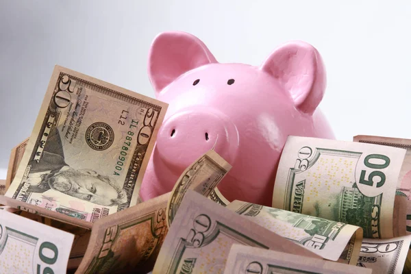 Piggy banco estilo caixa de dinheiro em segundo plano com dinheiro americano notas de cem dólares — Fotografia de Stock
