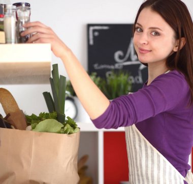 Masasının yanında duran genç bir kadın.