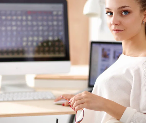 Jonge vrouw werkt in het kantoor, zit aan het bureau — Stockfoto