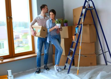 Mutlu genç çift açma veya kutu ambalaj ve yeni evine taşıdıktan