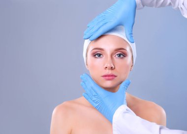 Güzel kadın yüz kozmetik enjeksiyon. Gri arka plan üzerinde izole