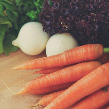 Mutfaktaki masanın üstünde sebzeler var.