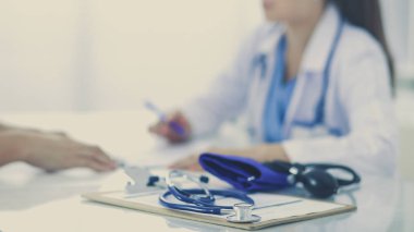 Hastanede masasında oturan genç bir kadın doktorun portresi.