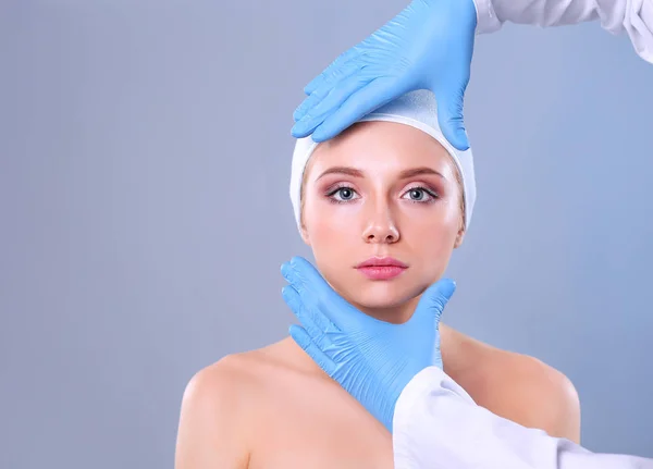 Kosmetikspritze auf das hübsche Frauengesicht. isoliert auf grauem Hintergrund — Stockfoto